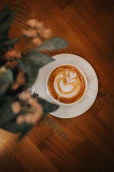 Top view of a creamy latte with foam art on a wooden table, taken in Ankara, Turkey.