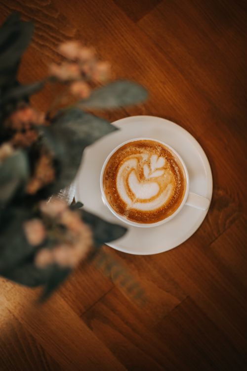 Free Top view of a creamy latte with foam art on a wooden table, taken in Ankara, Turkey. Stock Photo