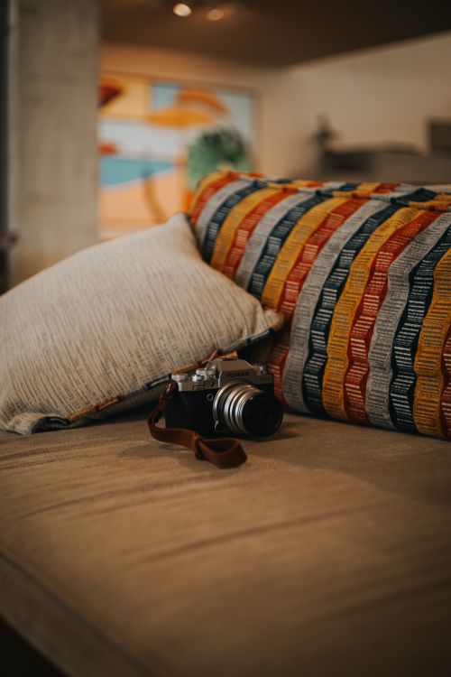 Free Vintage camera resting on a cozy multi-colored sofa in Ankara, Türkiye. Perfect blend of comfort and photography. Stock Photo