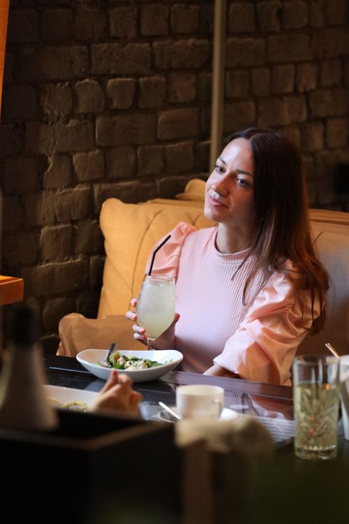 Free Woman in a stylish outfit drinking lemonade at a chic restaurant. Stock Photo