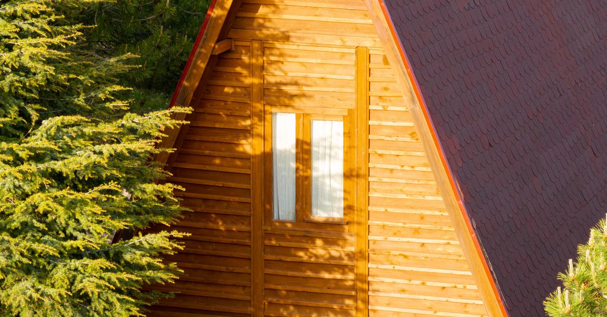A beautiful wooden cabin nestled in a lush forest, showcasing rustic architecture and serene nature.