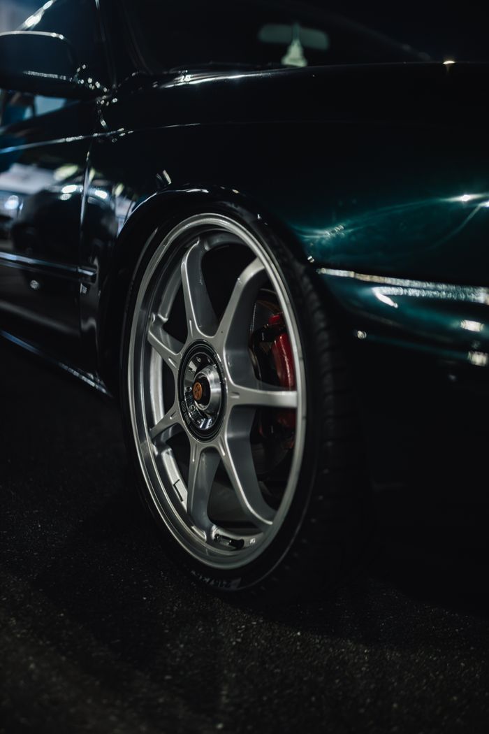 Wheel of a dark green car at night