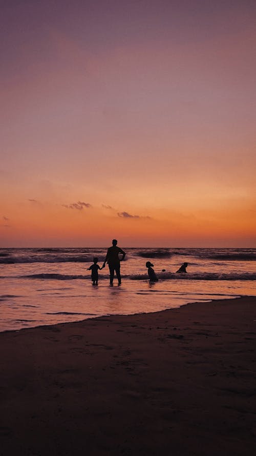 Parent and Children on Sea Shore at Sunset