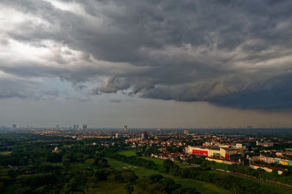 Aerial view of Serpong cityscape under dark, dramatic cloudy sky.