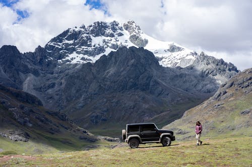 Woman and an Off Road Car in a Mountain Valley 