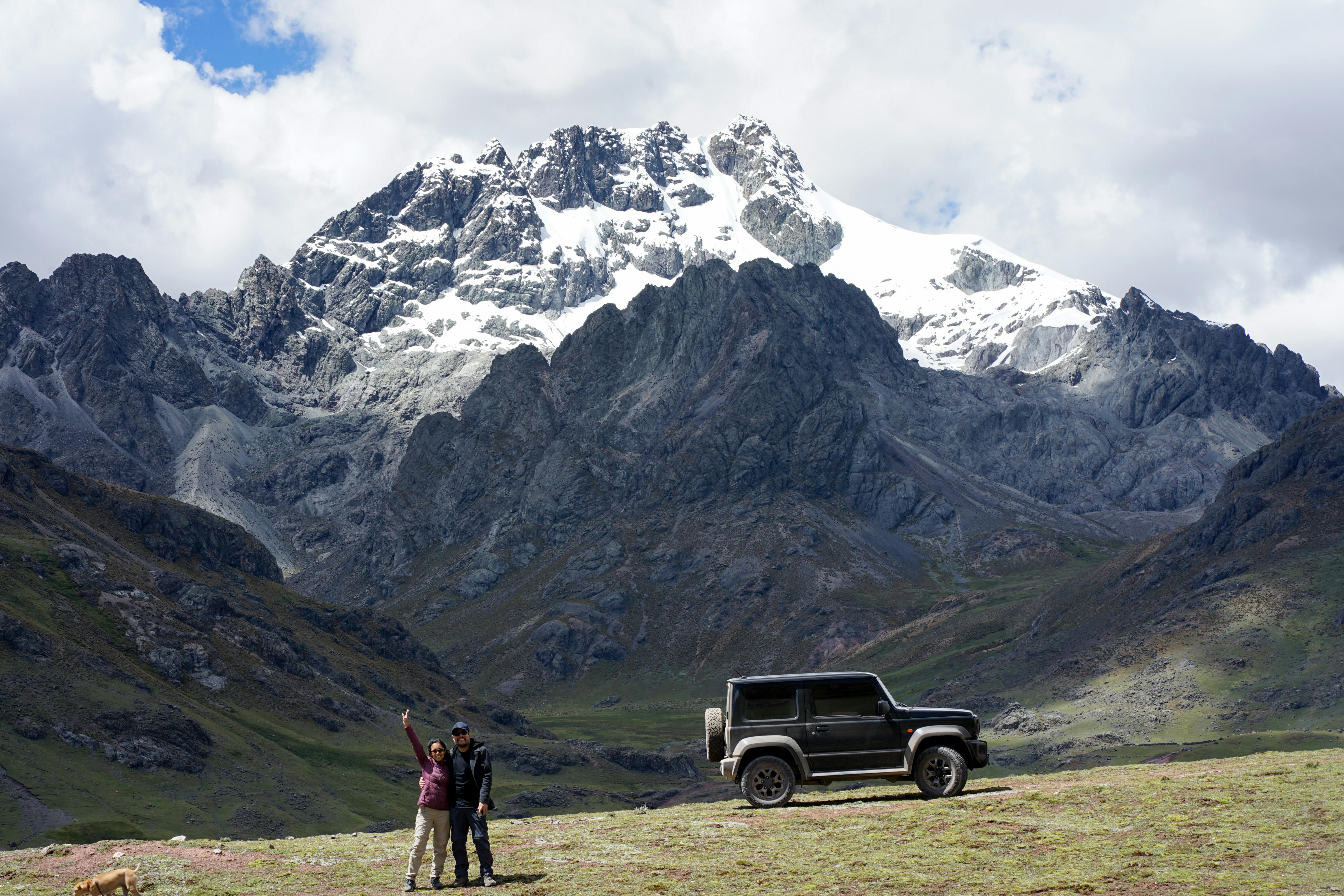Explore the breathtaking Andes with this adventurous expedition featuring a rugged SUV and stunning snowcapped peaks.
