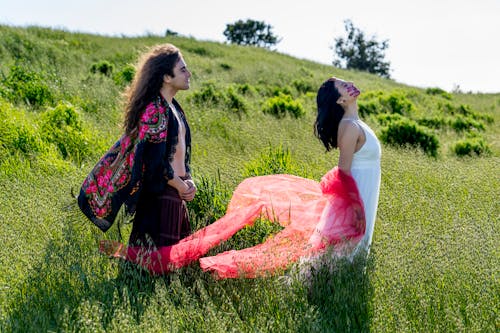 Man with Long Hair and Woman Standing on a Meadow 