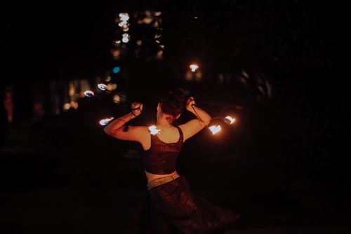 Free Captivating fire dancer performing during a nighttime show with blazing tools. Stock Photo