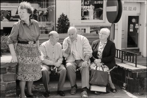 Free A group of seniors sharing a conversation in a city street setting during the day. Stock Photo