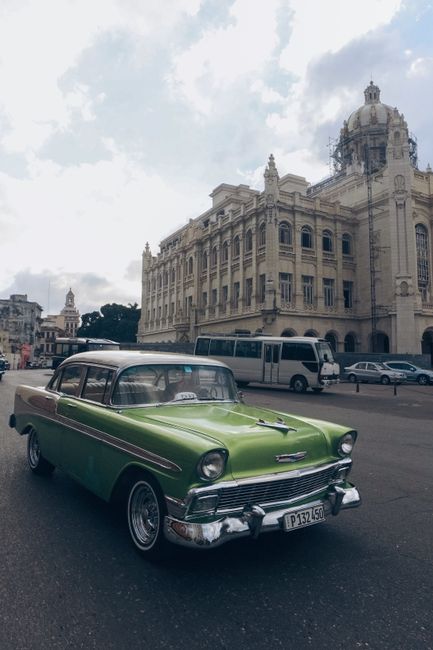 A classic green Chevrolet Bel Air cruising through historic Havana, Cuba, showcasing vintage urban charm.