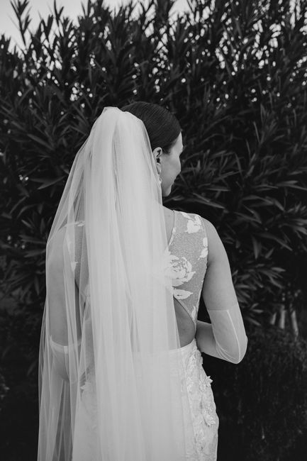 Black and white photo of a bride in a flowing dress and veil.