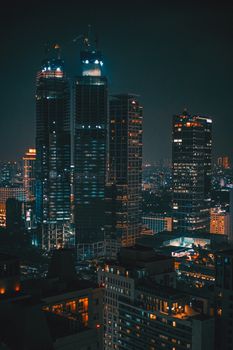 Vibrant cityscape of Jakarta's illuminated skyscrapers at night.