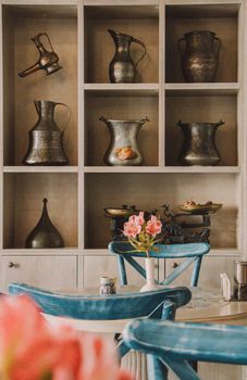 A charming vintage café interior featuring rustic metal pitchers and floral decor.
