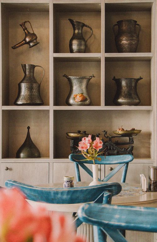 Free A charming vintage café interior featuring rustic metal pitchers and floral decor. Stock Photo