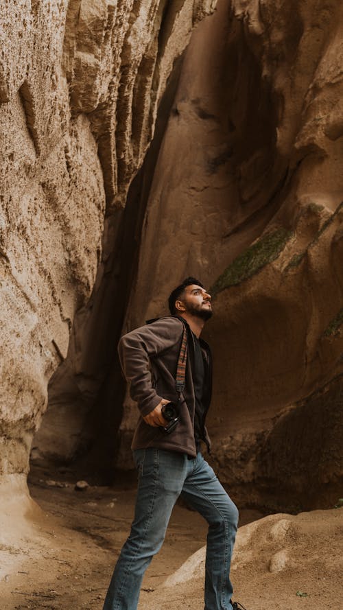 Free Man Looking Up in Cave Stock Photo