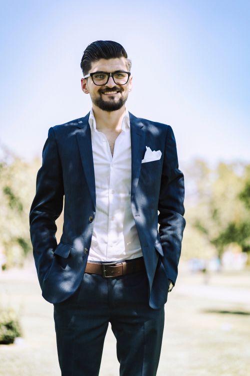 Free Handsome man in a stylish suit smiles confidently outdoors in Gaziantep, Turkey. Stock Photo