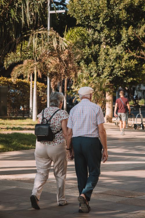Free Elderly couple strolling hand in hand on a sunny day in Málaga, Spain. Stock Photo