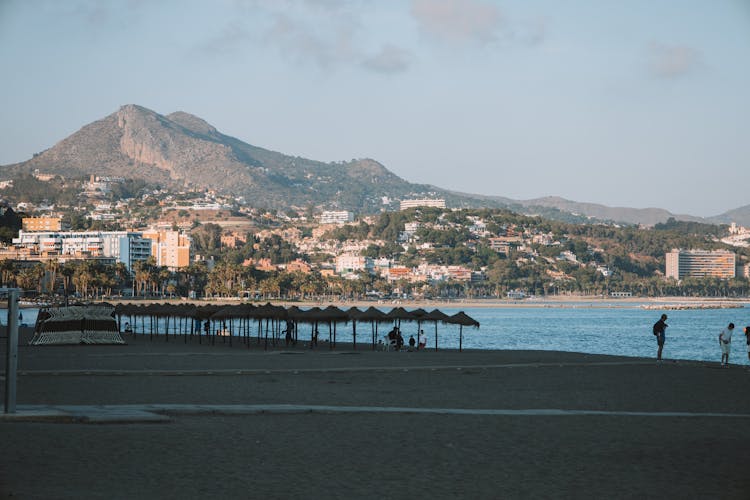 People On Sand Beach On Sunset