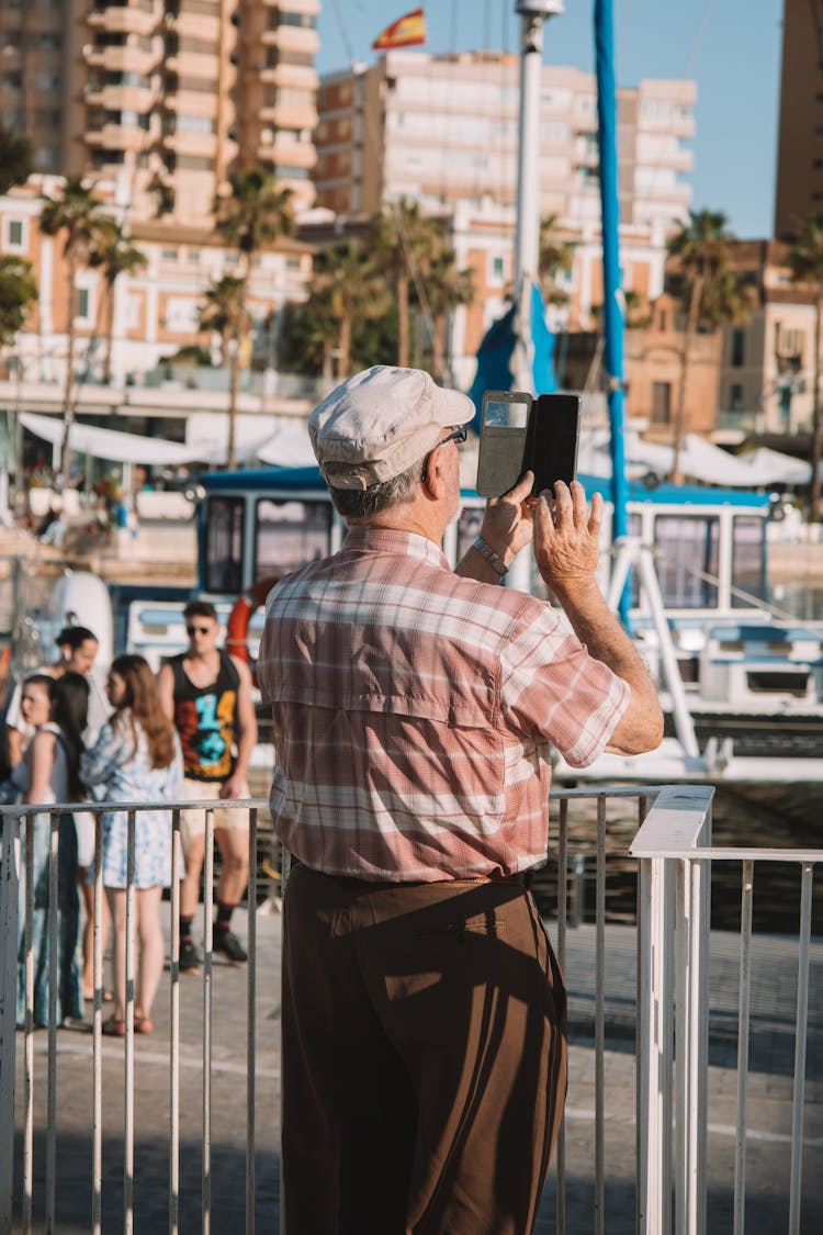 Old Man Taking Picture With Smartphone In Harbor