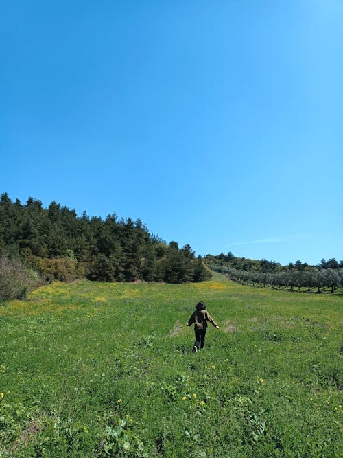 Girl Running on Sunlit Grassland