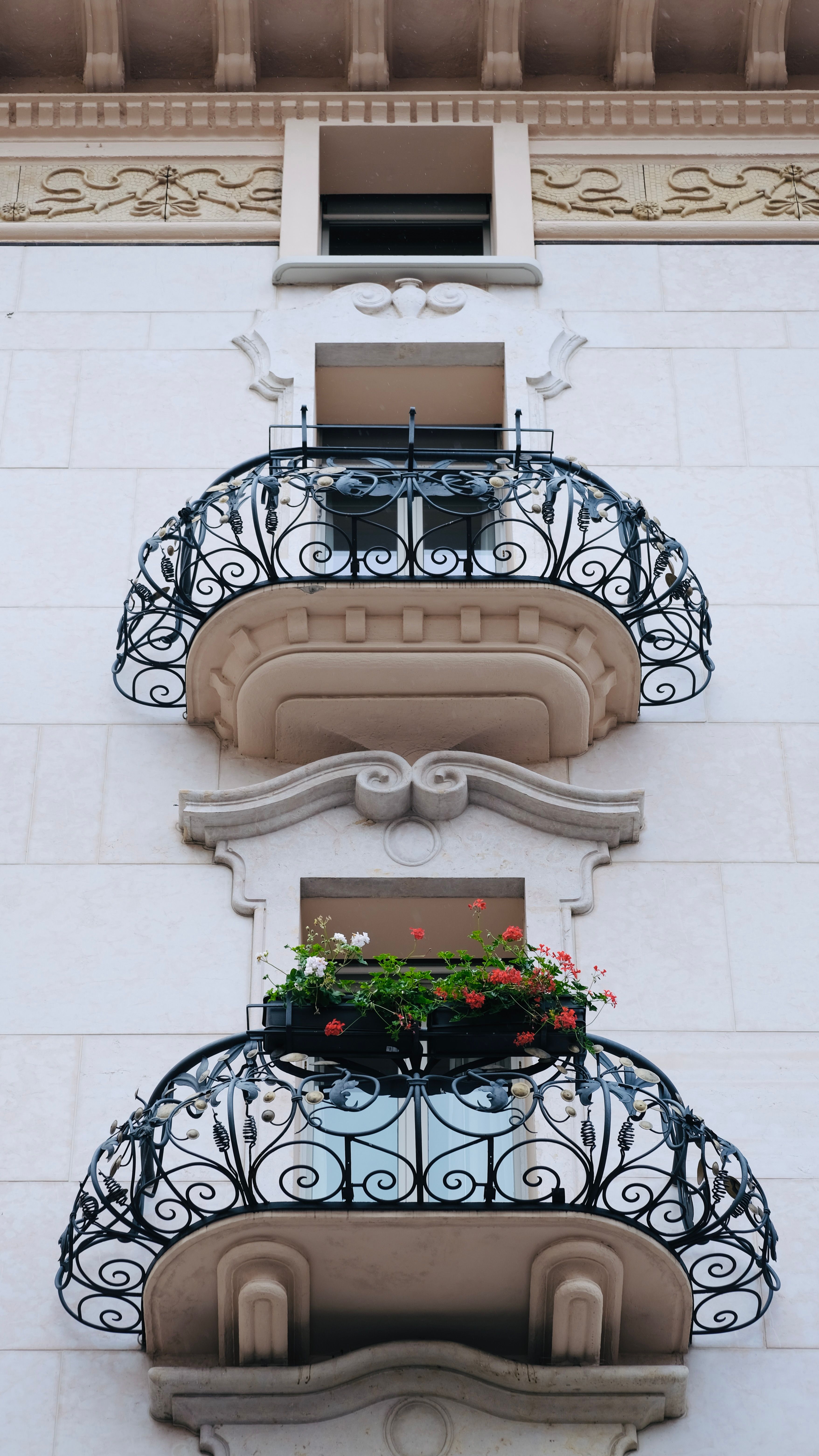 Balcoane din fier forjat cu model ornamental bogat, pe fațada unei clădiri vechi