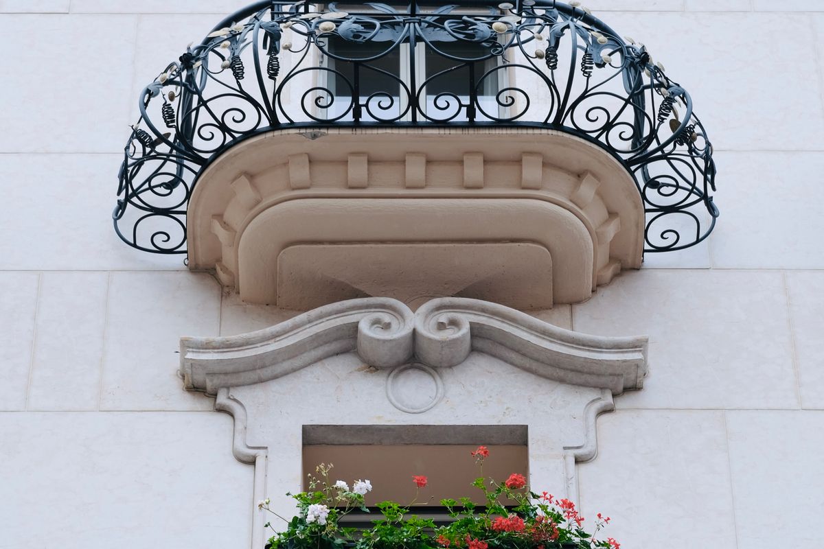Balcoane din fier forjat cu model ornamental bogat, pe fațada unei clădiri vechi