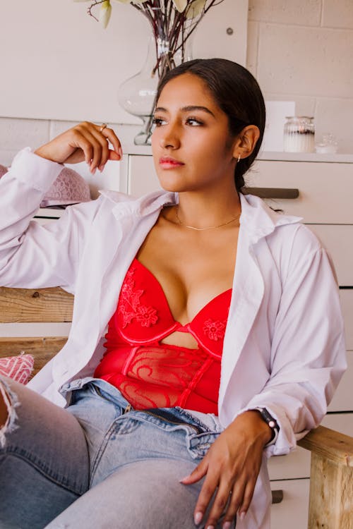 Model in Jeans, Unbuttoned Shirt and Red Bodysuit