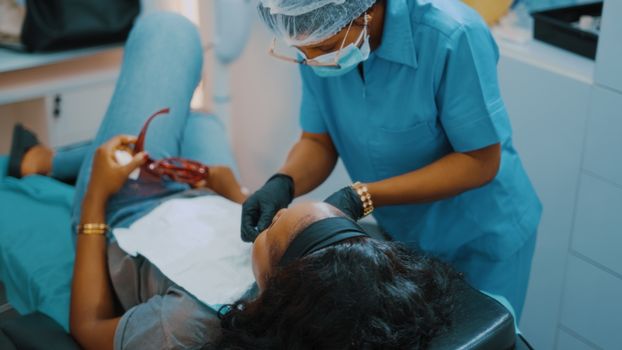 A woman getting her teeth checked by a dentist