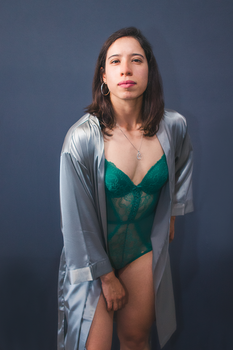 A portrait of a woman in fashionable attire captured in a studio setting with a minimalist approach.