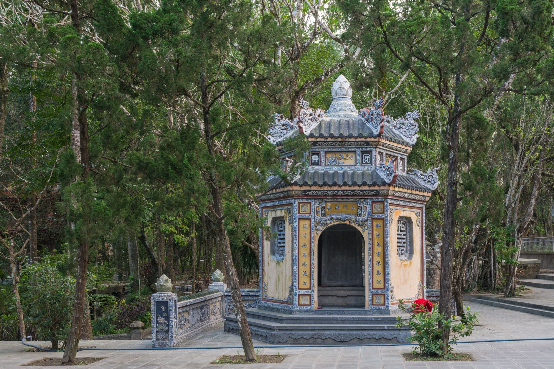 Tranquil scene of a historic pagoda surrounded by lush greenery in Huế, Vietnam.