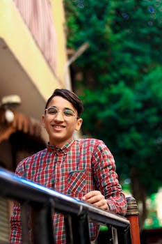 一个戴着眼镜、穿着格子衬衫的户外微笑青少年肖像