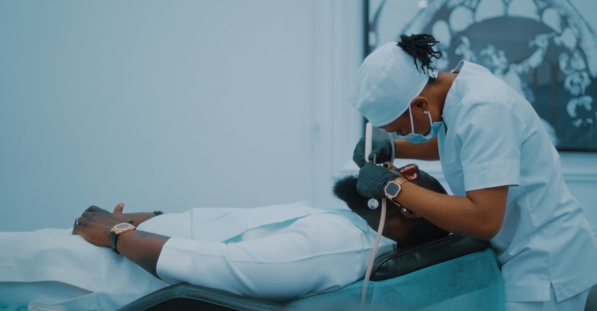 A dental professional performs a procedure on a patient in a clinic
