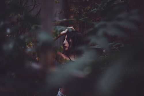 Free A woman in a forest, with a mysterious and moody atmosphere. Stock Photo
