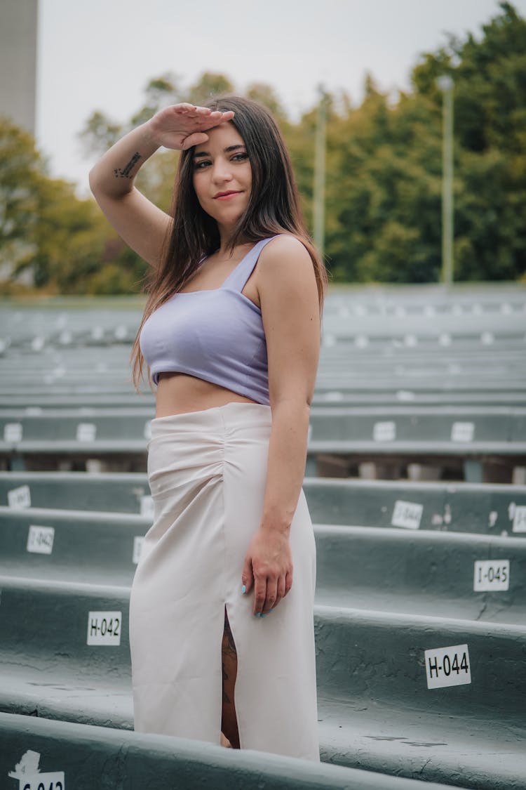 Woman In Skirt Posing With Hand Over Forehead