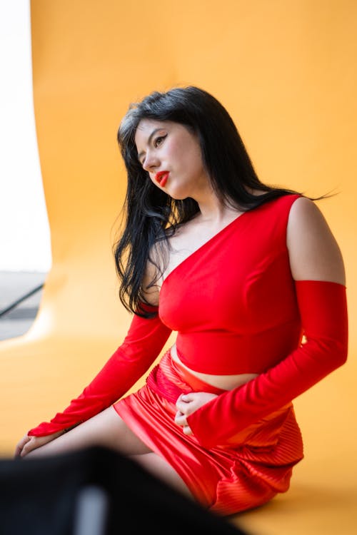 Woman Sitting and Posing in Red Clothes