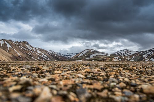 Free Brown Field Near Mountain Under Cloudy Sky Stock Photo