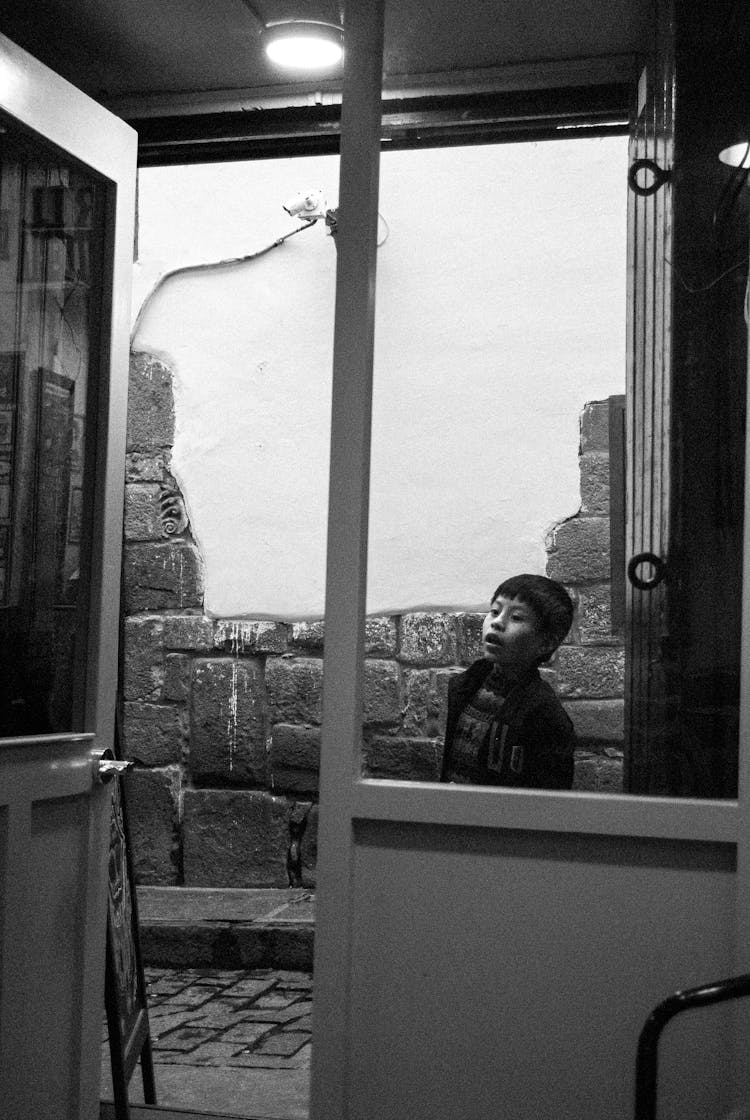 Boy Looking Into Store From Street