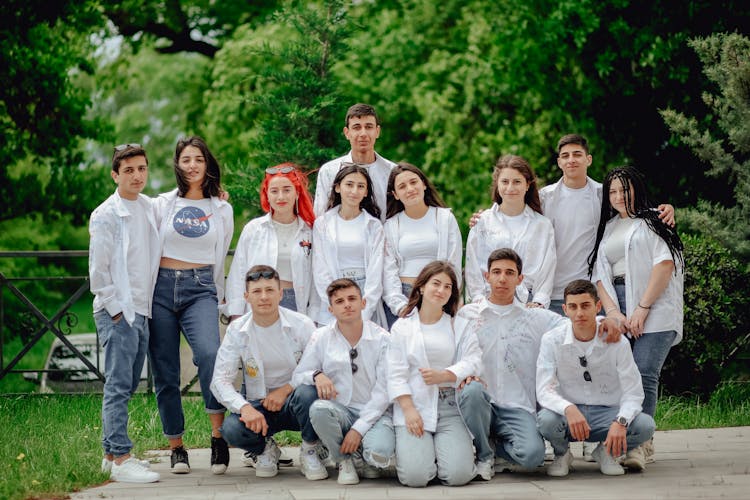 A Group Portrait Of Young People Posing In White Shirts