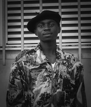 一位时尚男子的单色肖像，他穿着图案夹克，戴着贝雷帽