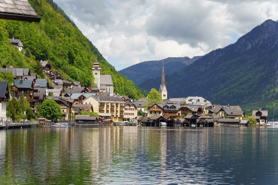 Vue pittoresque du village de Hallstatt en Autriche avec une toile de fond montagneuse et des reflets sur le lac.