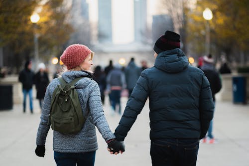 Pria Dan Wanita Berpegangan Tangan Saat Berjalan Di Taman
