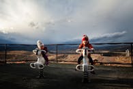 两个年幼的孩子在风景优美的户外操场上骑车玩耍