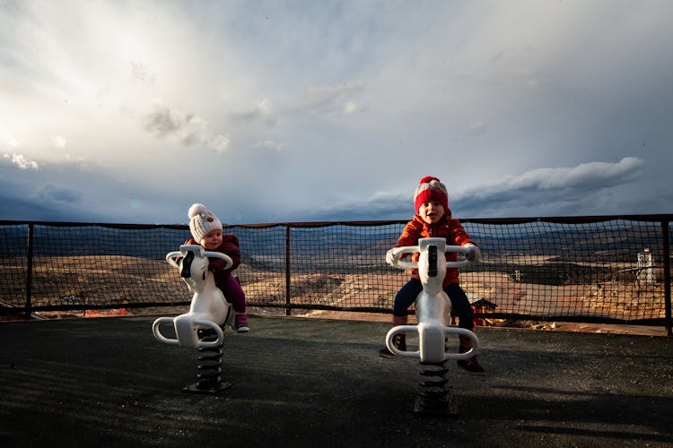 Photo Of Toddlers Riding On Spring Horses