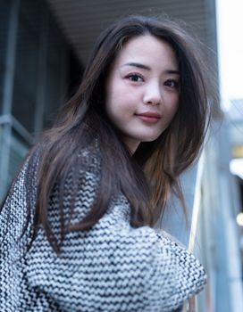 现代城市环境中，一位穿着图案毛衣的时尚女性肖像