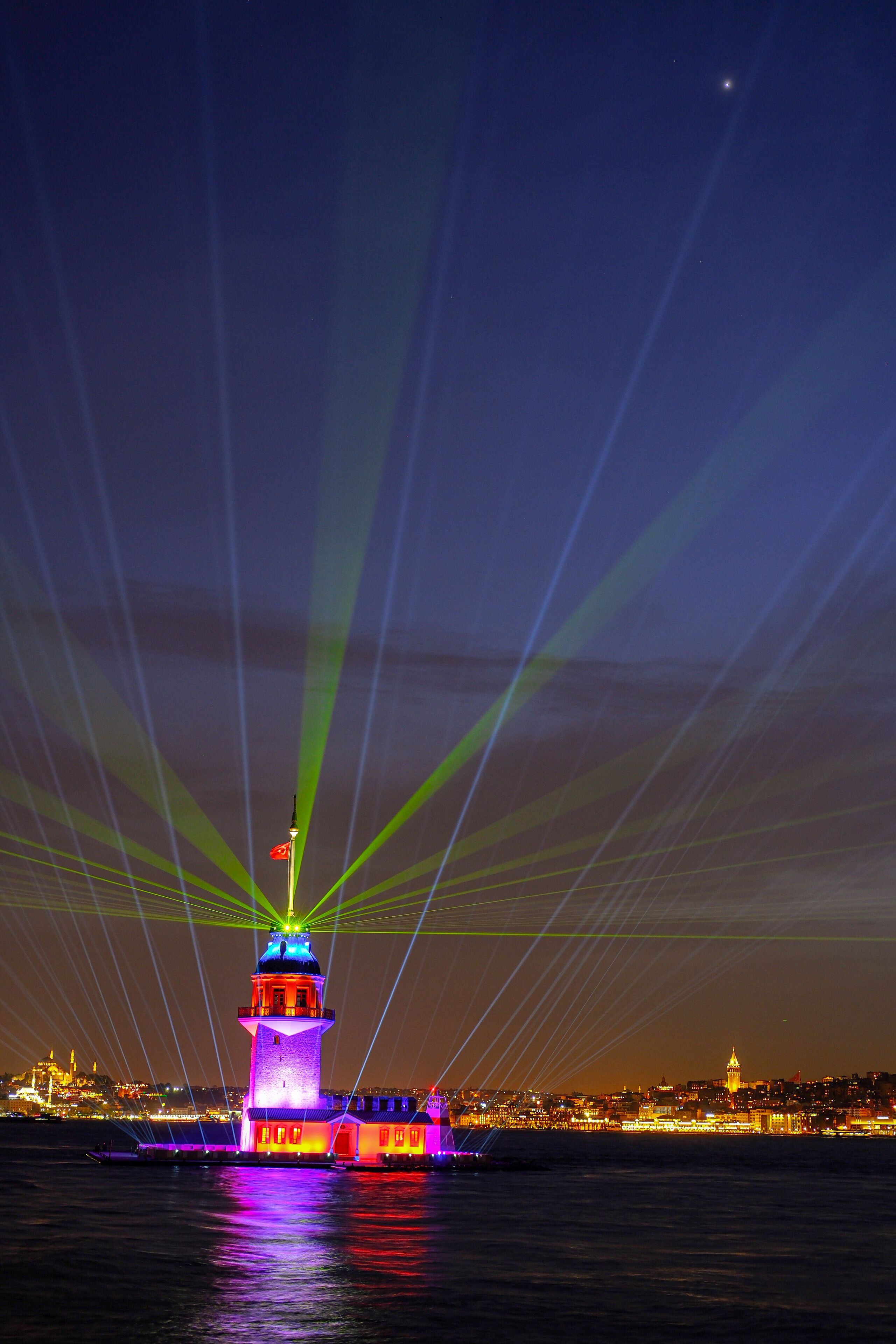 A lighthouse is lit up with colorful lights · Free Stock Photo