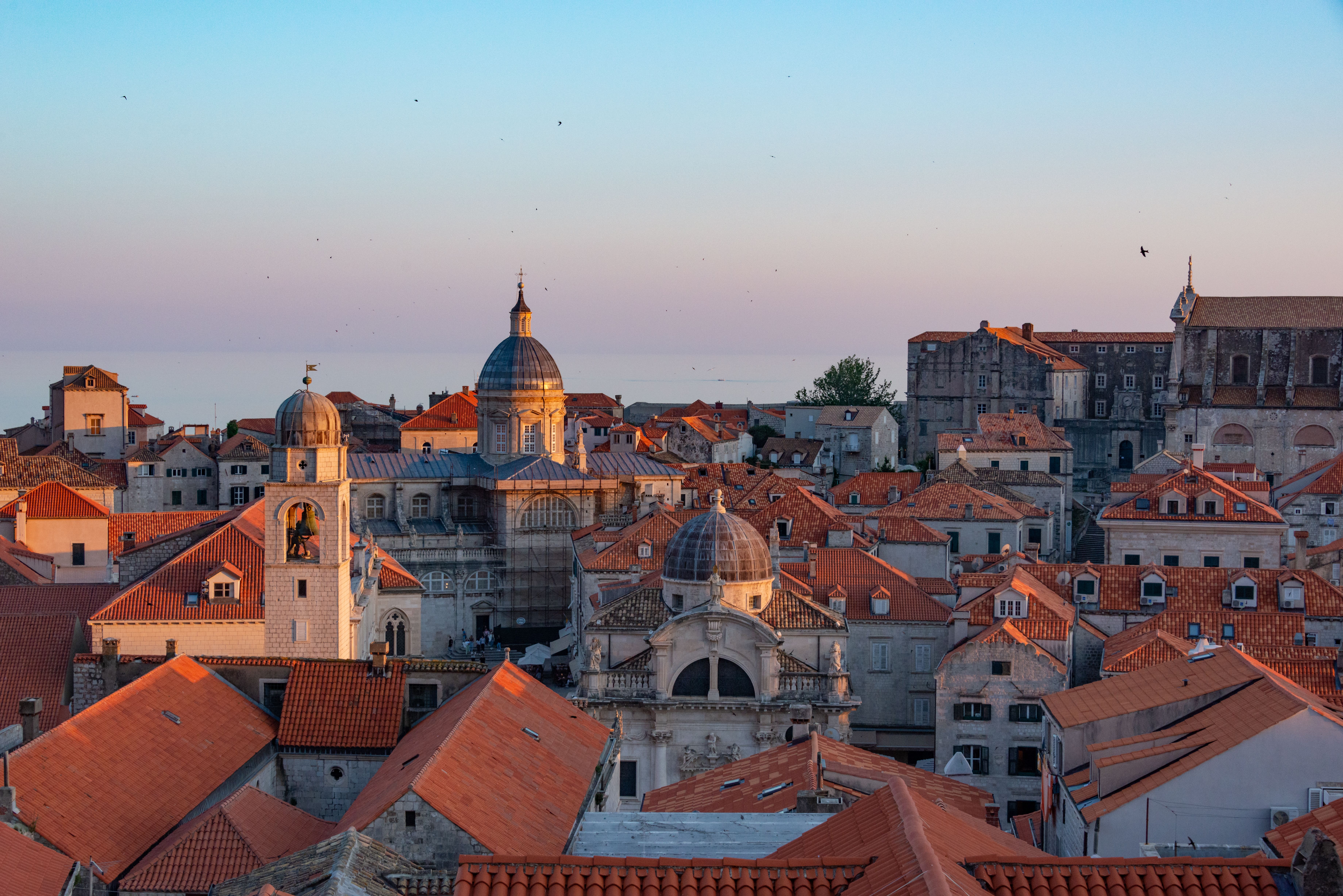 Dubrovnik city walls above red rooftops with Lokrum island offshore