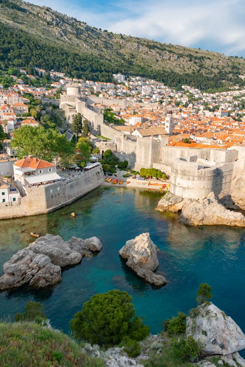 Free A picturesque aerial view of Dubrovnik's ancient city walls and harbor in summer, capturing the essence of a coastal vacation. Stock Photo