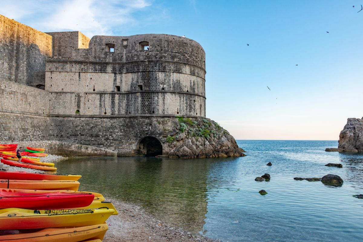 Kayaks lined up by Dubrovnik's historic Bokar fortress on a sunny day