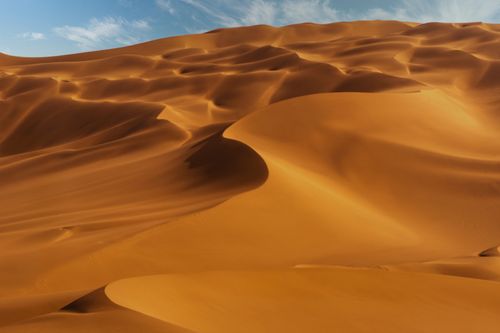 Free Explore the breathtaking beauty of vast desert sand dunes under a clear blue sky. Stock Photo