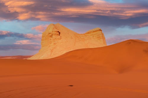 Rock Formation and Desert Landscape under Dramatic Sky 